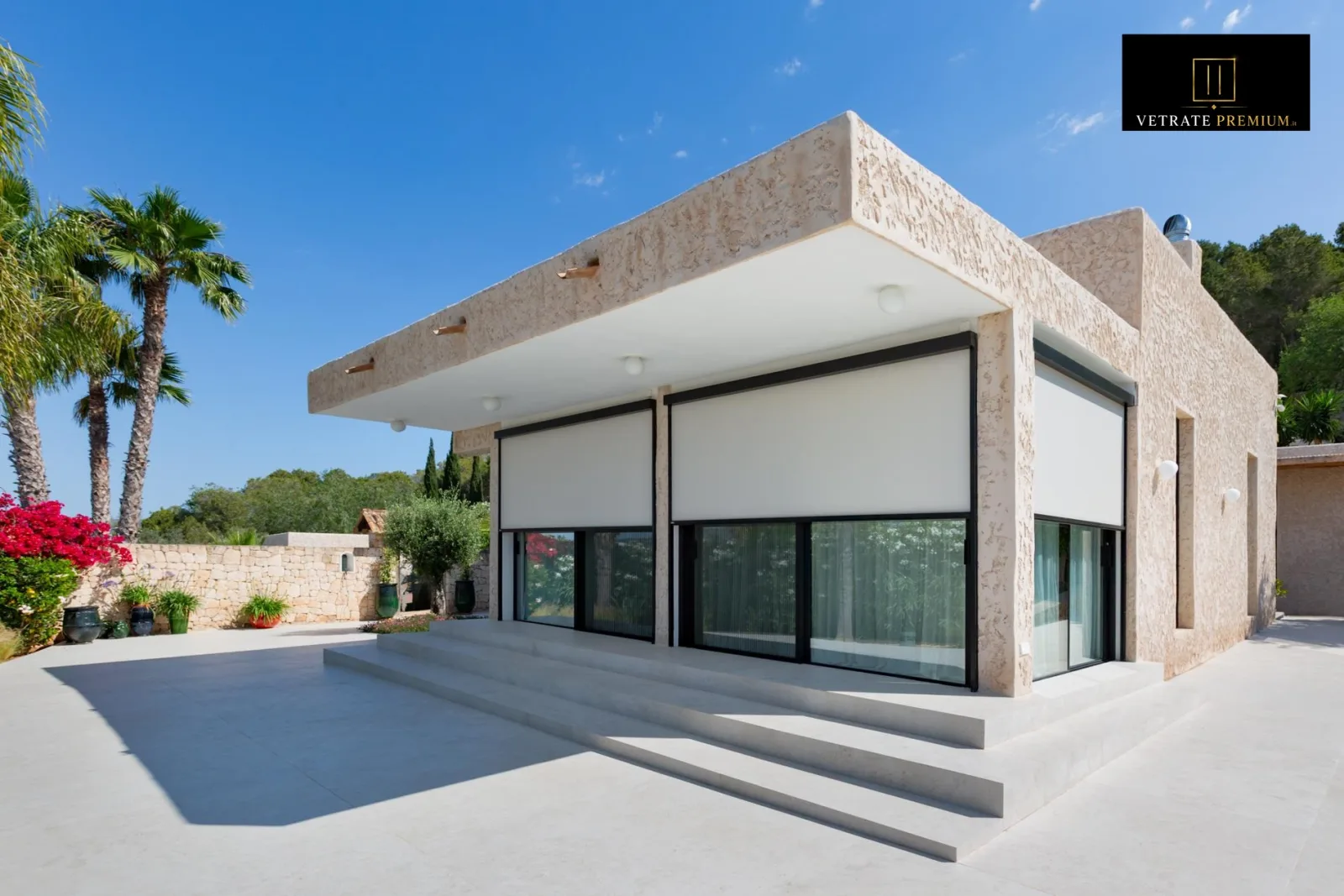 Oscuranti screen chiari su villa mediterranea in pietra: luce filtrata e calore bloccato senza rinunciare alla vista — VetratePremium Puglia