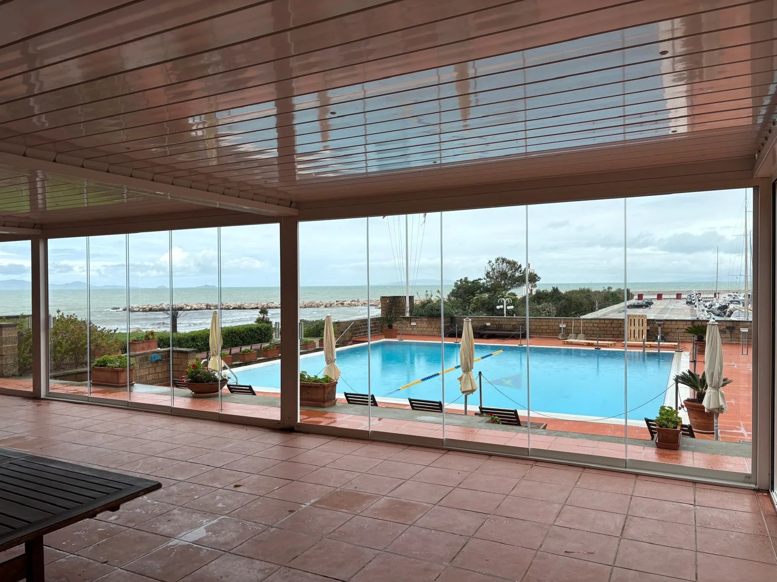 Rooftop lounge con vetrate panoramiche scorrevoli — dehors ristorante premium vista panoramica serale — VetratePremium